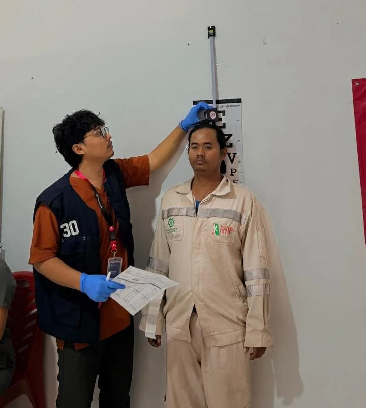 Karyawan berseragam kerja industri menjalani pemeriksaan oleh tim medis pada MCU onsite di lokasi perusahaan