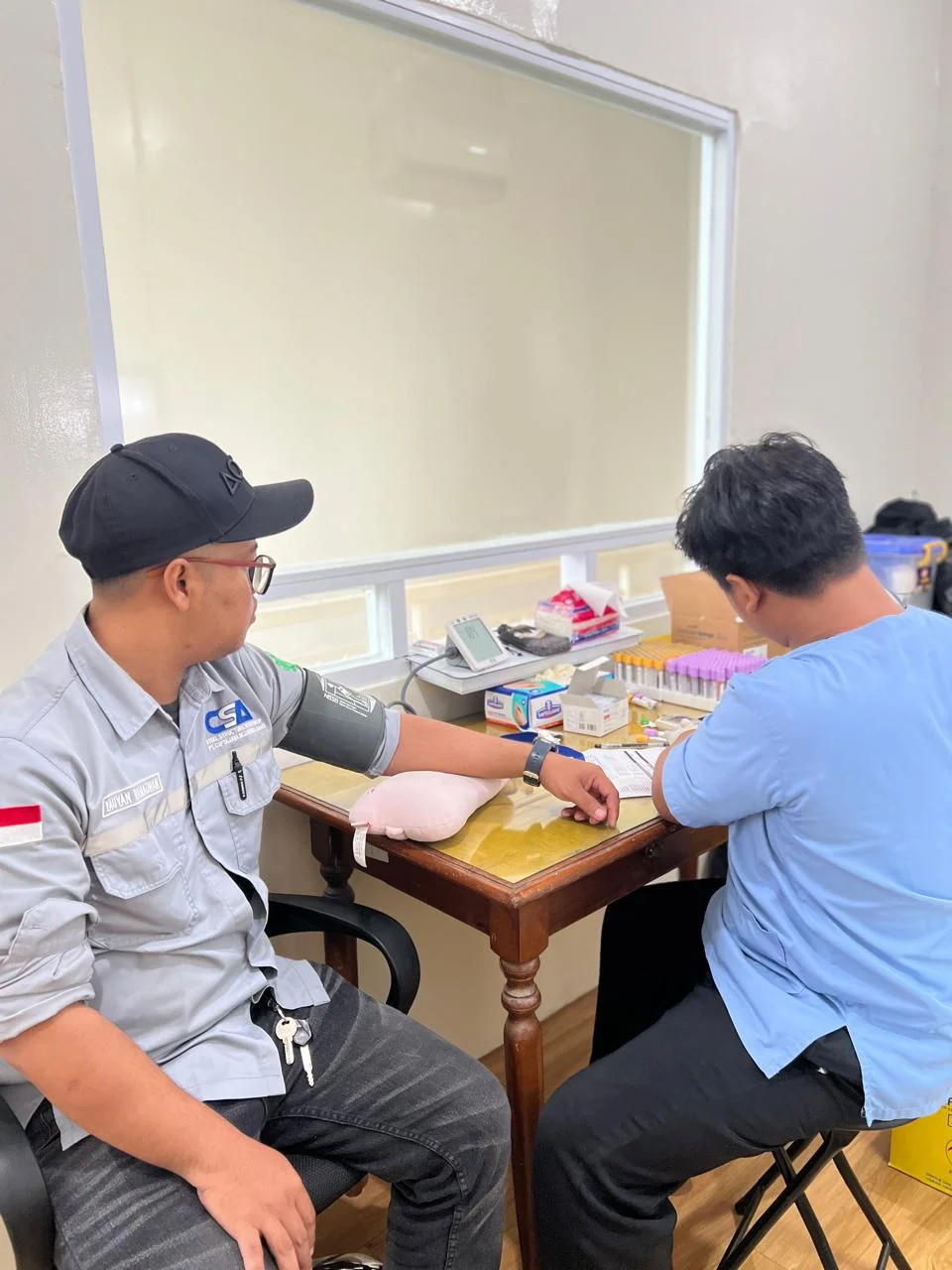 Pengambilan sampel darah karyawan berseragam kerja untuk pemeriksaan fungsi hati dalam MCU perusahaan